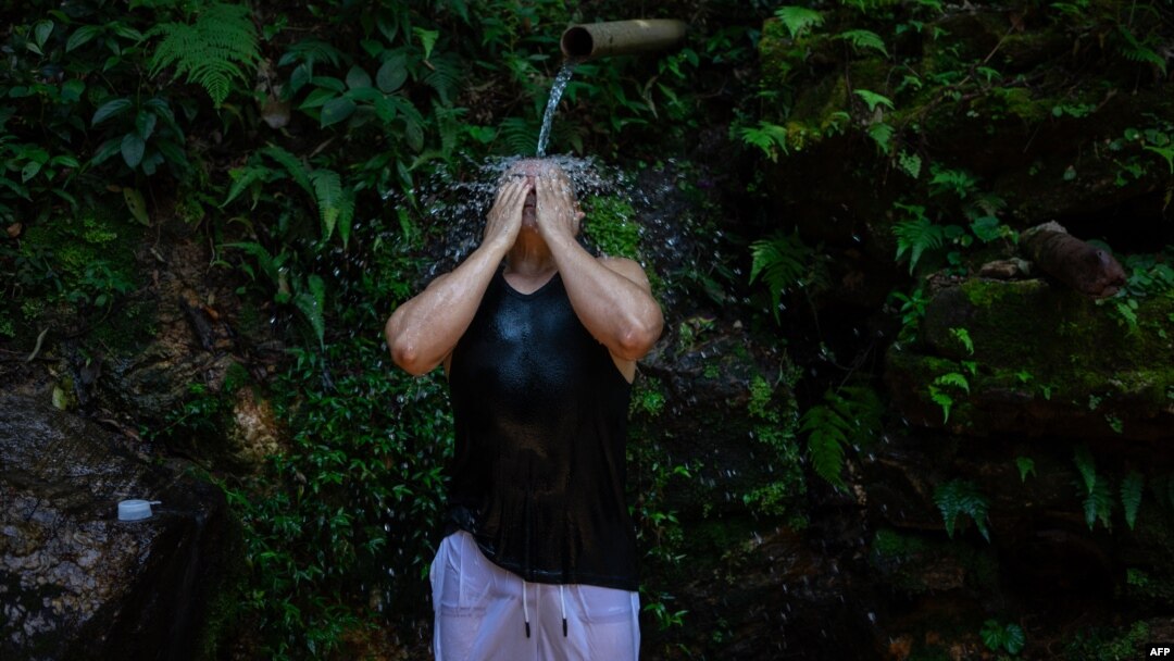  Una residente de una favela de Río de Janeiro, en Brasil, se refresca de un manantial natural durante una ola de calor extremo en la ciudad el 17 de noviembre de 2023. Archivo.