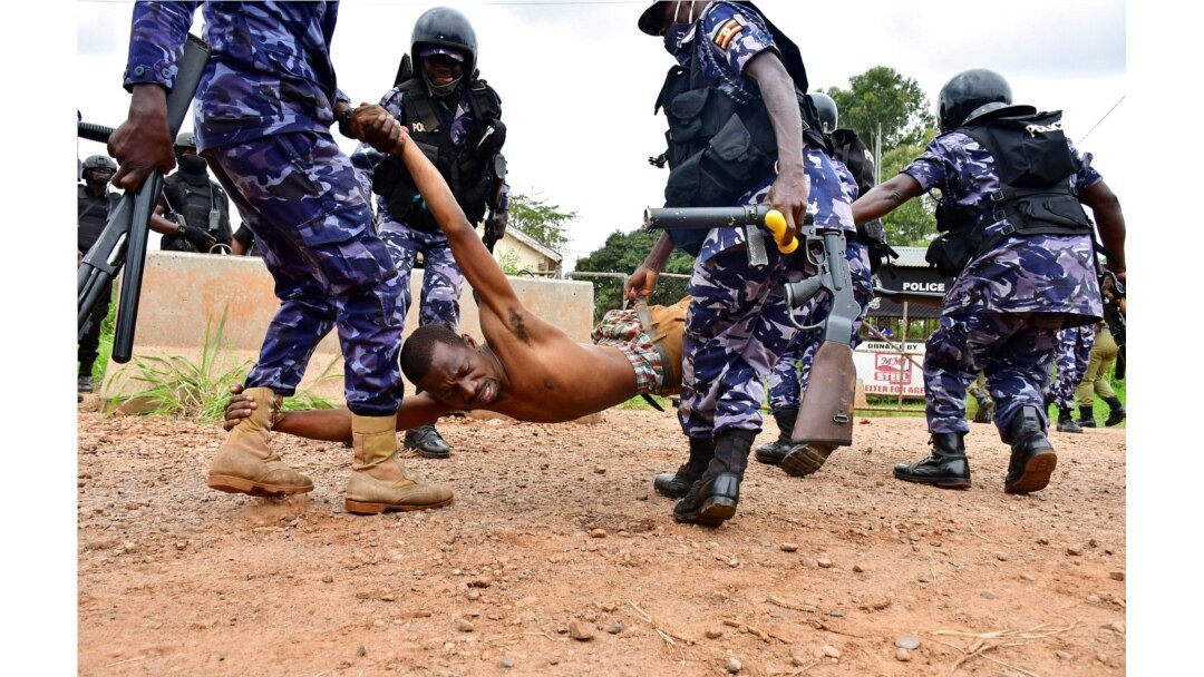 FILE - Riot policemen detain a supporter of presidential candidate Robert Kyagulanyi, also known as Bobi Wine, in Luuka district, Uganda, Nov. 18, 2020.