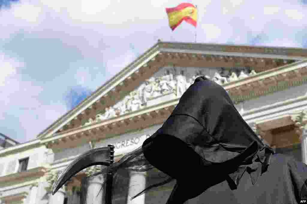 A protester dressed as Death demonstrates against a law legalizing euthanasia, as Parliament gives final approval to bill decriminalizing euthanasia and doctor-assisted suicide, in Madrid, Spain.