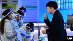 Seorang pria menjalani tes swab di bandara internasional Los Angeles, California sementara kota ini melaporkan kasus pertama varian omicron (3/12). 