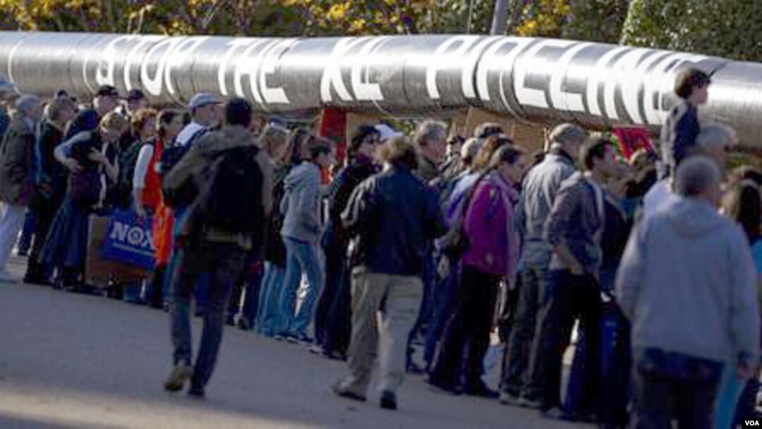 Ribuan pengunjuk rasa membawa replika pipa minyak Keystone XL di depan Gedung Putih (6/11).