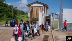 FILE - Deported migrants enter El Ceibo, Guatemala, on the border with Mexico, Aug. 12, 2021. The migrants, mostly Central Americans, were detained in southern Mexico as they were trying to reach the United States.