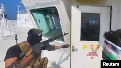 (FILE) Houthi fighters open the door of cockpit on the ship's deck in the Red Sea.