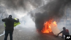 Des manifestants gilets jaunes ont mis le feu à une barricade sur l'avenue des Champs-Élysées, le 16 mars 2019 à Paris.