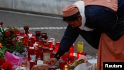 A nun places an object at a makeshift memorial outside Gemelli Hospital, where Pope Francis is a patient, in Rome, March 8, 2025.