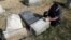 A Trump supporter named Bob, who declined to give his last name, volunteers his time and prepares the base of a damaged headstone, Feb. 28, 2017, in Philadelphia. Scores of volunteers are expected to help in an organized effort to clean up and restore the Jewish cemetery where vandals damaged hundreds of headstones.
