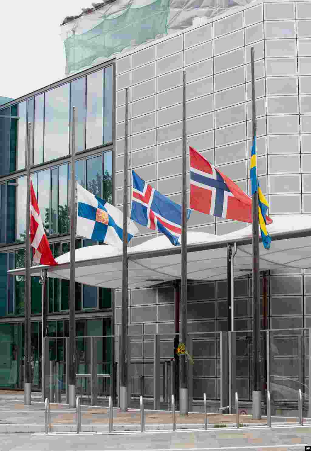 The flags of Scandinavian countries fly at half-staff in front of the Scandinavian and Nordic Embassies' building in Berlin, Germany. (AP)