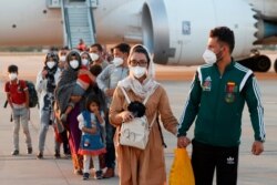 FILE - The captain of Afghanistan's women's wheelchair basketball team Nilofar Bayat, 2nd right, and her husband disembark from a Spanish evacuation airplane, that landed at the Torrejon de Ardoz air base, August 20, 2021.