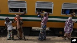 Passengers aboard an Ooni of Ife train to Kano, buy drinks and water at a train terminal in Mnna, Nigeria.