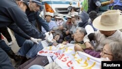 29일 일본 오키나와현 미군 기지 앞에서 공사에 반대하는 시위대가 경찰과 몸싸움을 벌이고 있다. 