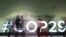 Personas caminan frente a un cartel sobre la Cumbre Climática de la ONU COP29, el 13 de noviembre de 2024, en Bakú, Azerbaiyán.