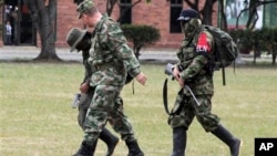 A Colombian soldier, left front, escorts rebels of the National Liberation Army, ELN, who gave themselves up at a military base in Cali, July 16, 2013.