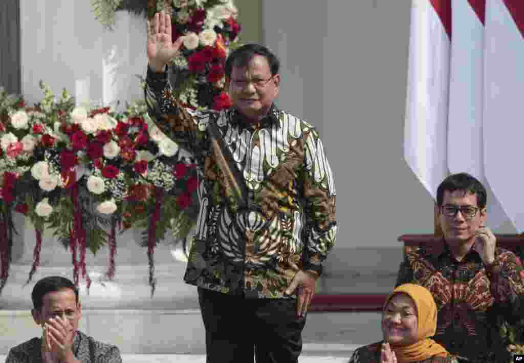 Menteri Pertahanan Prabowo Subianto, yang menjadi pesaing Presiden Joko Widodo dalam pilpres April lalu, melambaikan tangan saat namanya diumumkan, di Istana Merdeka, Jakarta, 23 Oktober 2019. (Foto: Dita Alangkara/AP)