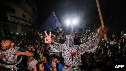 Palestinians celebrate in the streets following a cease-fire brokered by Egypt between Israel and the ruling Islamist movement Hamas in the Gaza Strip, on May 21, 2021, in Gaza City.