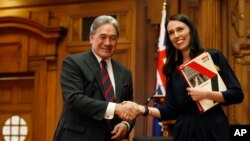 New Zealand First leader Winston Peters, left, and Prime Minister-designate Jacinda Ardern shake hands after signing a coalition agreement on Tuesday, Oct. 24, 2017, in Wellington. New Zealand.