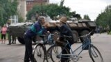 Local residents talk in front of an Ukrainian armored personnel carrier (APC) in the eastern Ukrainian city of Slavyansk.
