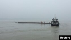 Para petugas penyelamat dekat kapal tenggelam di Sungai Yangtze, provinsi Hubei, China (2/6). 