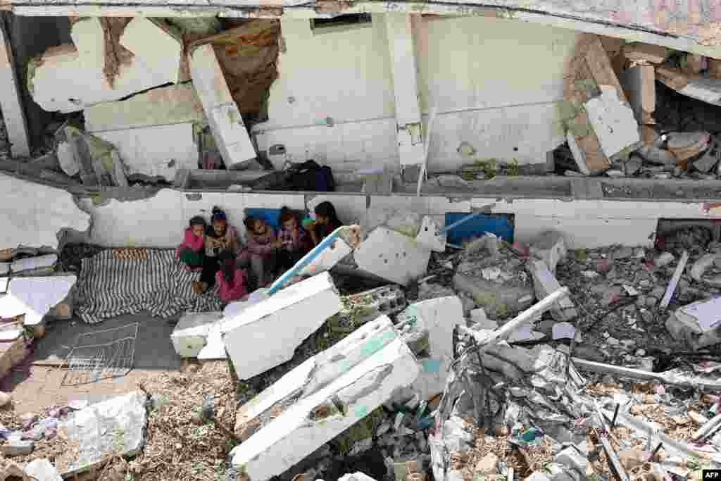 Displaced Palestinian children sit amid the rubble of a destroyed building in the Nasser district of Gaza City, in the northern Gaza Strip.