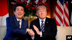 Prezidan Donald Trump , adwat, ak Premye Minis japonè a Shinzo Abe, agoch, pandan yon rankont nan klèb Mar-a-Lago Mesye Trump la nan Palm Beach, Florid.