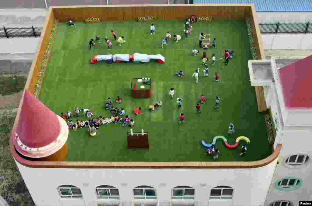 Teachers and students exercise on the playground located on the roof of a kindergarten building in Xi&#39;an, Shaanxi province, China, Oct. 20, 2015.