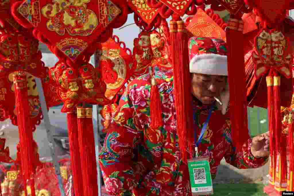 A vendor selling Spring Festival ornaments attends to customers at an outdoor market ahead of the Lunar New Year, in Beijing, China.