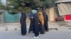 (FILE) In this photograph taken on June 26, 2024, Afghan women walk along a road during early morning in Kabul.