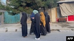 (FILE) In this photograph taken on June 26, 2024, Afghan women walk along a road during early morning in Kabul.