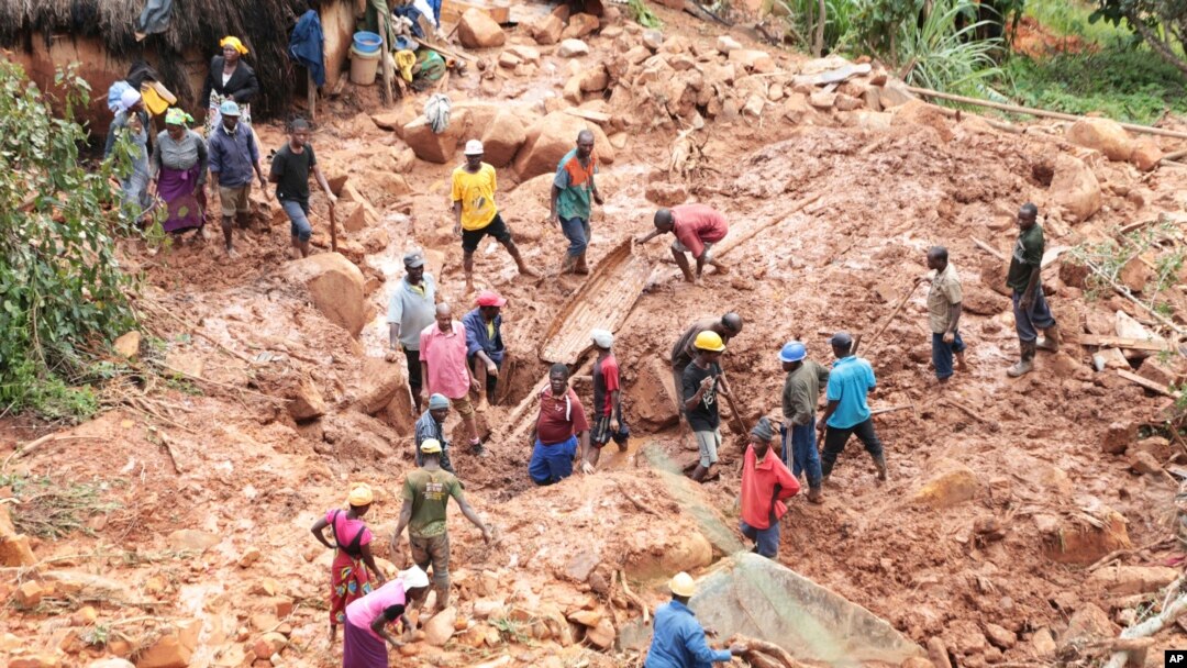 Umuryango utaburura umwana wabo warengewe n'igitaka catewe n'igihugusi Idai . Aha ni Chimanimani mu birometero 600 uvuye ku murwa mukuru Harare, Zimbabwe, 19, z'ukwa gatatu 2019. 