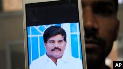 An employee of a local television channel shows a picture of slain journalist Aziz Memon on his mobile, after a demonstration to condemn his killing, in Hyderabad, Pakistan, Feb. 17, 2020. 