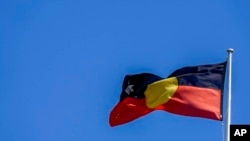 The Australian aboriginal flag flies on a building in Sydney, Australia, Oct. 7, 2021.