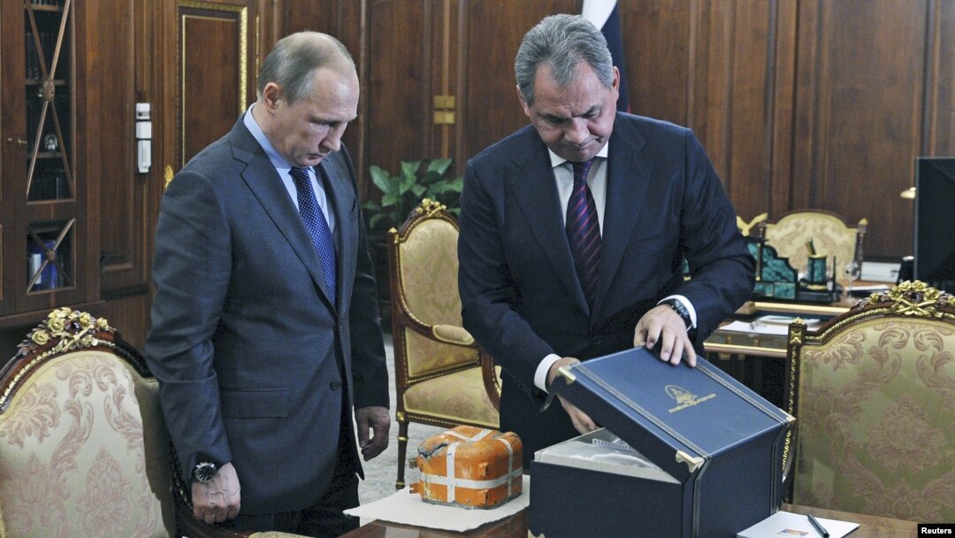 Menhan Rusia, Sergei Shoigu (kanan) menunjukkan kepada Presiden Rusia Vladimir Putin rekaman penerbagan pesawat pembom SU-24 yang ditembak jatuh Turki di Moskow, Rusia (8/12).