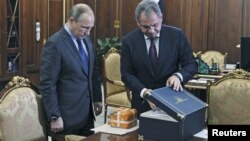 Russian Defense Minister Sergei Shoigu (R) presents to Russian President Vladimir Putin the parametric flight recorder of the downed SU-24 jet at the Novo-Ogaryovo state residence outside Moscow, Russia, Dec. 8, 2015.