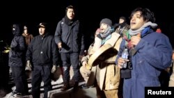 Opponents of the Dakota Access oil pipeline sing during a confrontation with police on Backwater Bridge near Cannon Ball, N.D., Jan. 19, 2017. 