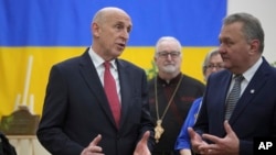 Britain's Defence Secretary John Healey, left, speaks to members as he visits the Ukrainian Catholic Church in central London, Nov. 19, 2024 to mark the 1000 days since Russia's invasion of Ukraine.