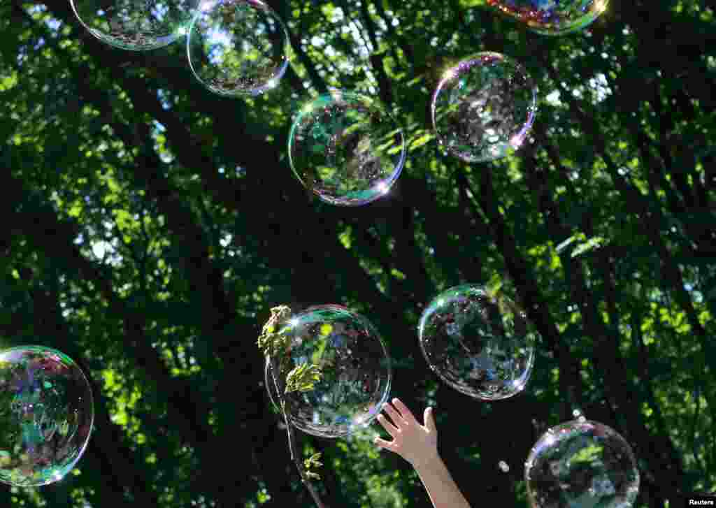 A child plays with soap bubbles at an event to support autistic children and their families in a park in Kyiv, Ukraine.