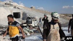 Des membres de la défense civile syrienne sur un site de la ville de Hass après une frappe aérienne dans le sud de la province syrienne d'Idlib, le 8 septembre 2018.