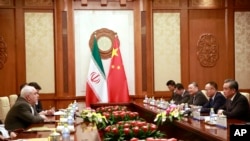 Iranian Foreign Minister Mohammad Javad Zarif, left, speaks with Chinese Foreign Minister Wang Yi during their meeting at the Diaoyutai State Guesthouse in Beijing, Aug. 26, 2019. (How Hwee Young/Pool Photo via AP)