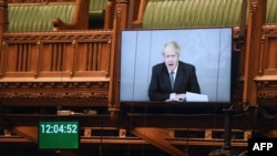 A handout photograph released by the UK Parliament shows a screen displaying an image of Britain's Prime Minister Boris Johnson as he takes questions remotely during a socially distanced session in the House of Commons, in London, Nov. 18, 2020.