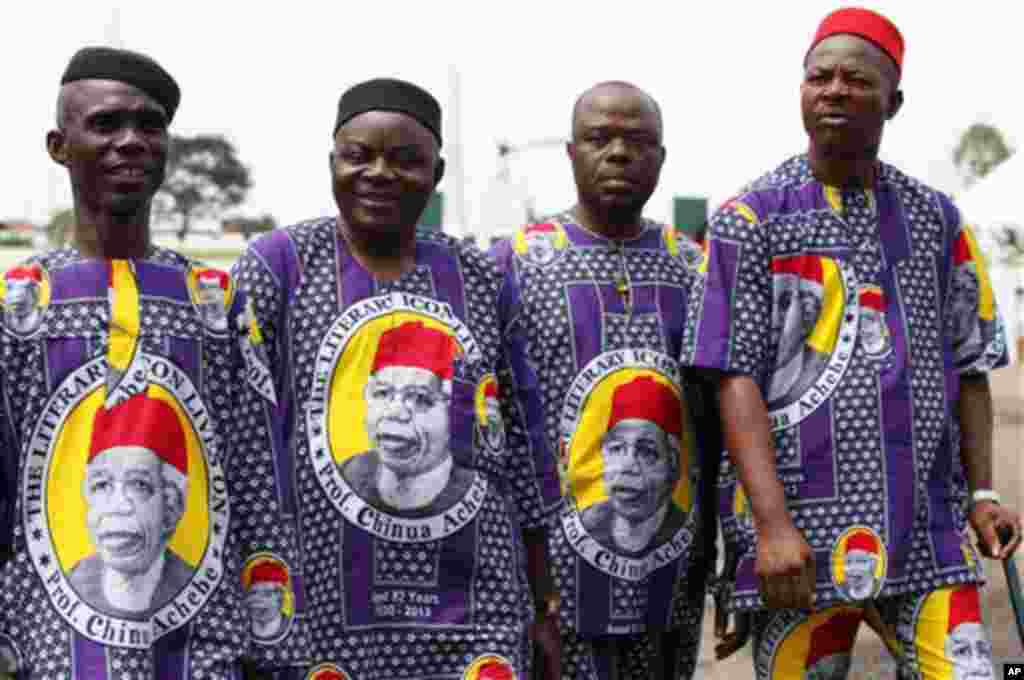 Men wear African print fabric bearing the image of the late author Chinua Achebe, in  Awka, Nigeria, Wednesday, May 22, 2013.
