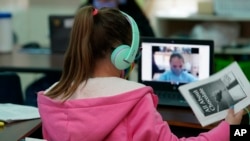 Students at Driggers Elementary School attend a class in-person as they interact with classmates virtually, Monday, Feb. 8, 2021, in San Antonio. (AP Photo/Eric Gay)