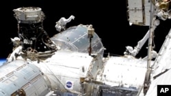 In this image from NASA video, astronaut Mike Hopkins works outside the International Space Station’s European lab, Jan. 27, 2021. Hopkins and Victor Glover conducted another spacewalk March 13, 2021.