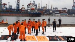 Tim SAR meletakkan kantong jenazah berisi jasad manusia yang ditemukan di lokasi jatuhnya pesawat Sriwijaya Air SJ182 di perairan laut Jawa, 10 Januari 2021. (Foto: Dany Krisnadhi / AFP)