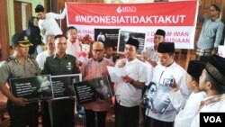 Seorang Gusdurian (tengah) membacakan pernyataan usai doa bersama di gereja St.Lidwina, Sleman Yogyakarta, Rabu (14/2). Disamping kiri/kanan: Romo Yohanes Dwi Harsanto dan Kyai Umaruddin Masdar. (Foto VOA/Munarsih)