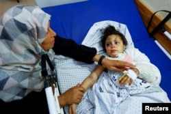 FILE - Palestinian girl Fulla Al-Laham, 4, who was wounded in an Israeli strike that killed 14 family members, including her parents and all her siblings, lies on a bed as her grandmother sits next to her, at a hospital in Khan Younis in the southern Gaza Strip, October 14, 2023.