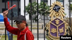 Pendukung pemerintah Thailand di luar gedung Komisi Nasional Anti-Korupsi di provinsi Nonthaburi, luar kota Bangkok (27/2). (Reuters/Chaiwat Subprasom)