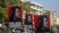 FILE - Anti-coup protesters display pictures of deposed Myanmar leader Aung San Suu Kyi in Yangon, Myanmar, March 2, 2021. 