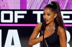 FILE - Ariana Grande accepts the award for artist of the year at the 2016 American Music Awards in Los Angeles, Nov. 20, 2016.