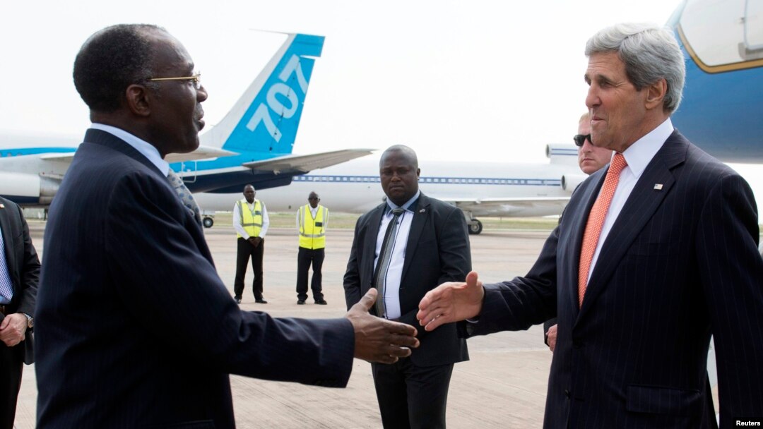 U.S. Secretary of State John Kerry (R) shakes hands with Democratic Republic of Congo Foreign Minister Raymond Tshibanda upon his arrival at N'djili Airport in Kinshasa, May 3, 2014. 