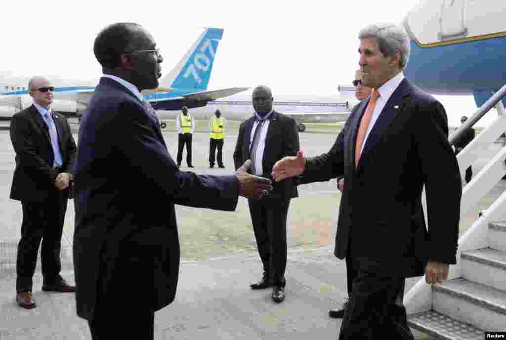 Kongo Demokratik Respublikasi Tashqi ishlar vaziri Raymond Tshibanda (chapda) Jon Kerrini aeroportda kutib olmoqda, Kinshasa, 3-may, 2014-yil.