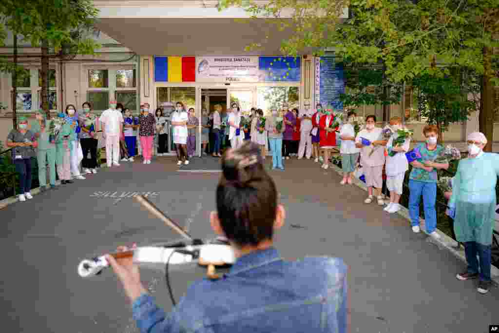 Medical staff of the Polizu maternity hospital listen to a violinist playing to entertain them and the patients in Bucharest, Romania.